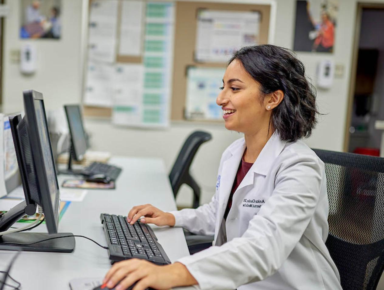 Healthcare worker studying data on computer.